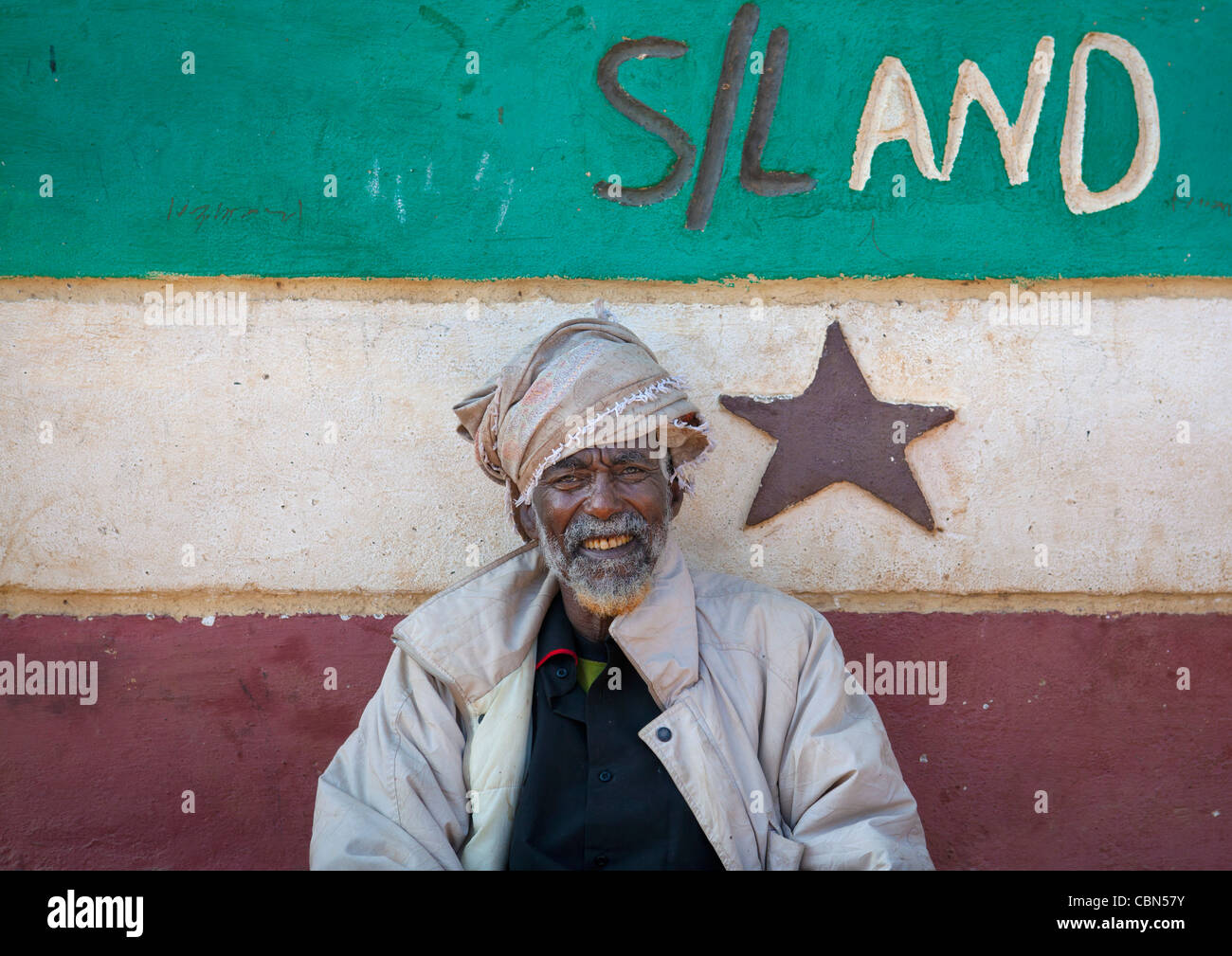 Ritratto di Senior bianco Turbanned barbuto uomo nero nella parte anteriore del Somaliland bandiera dipinta, Baligubadle Somaliland Foto Stock