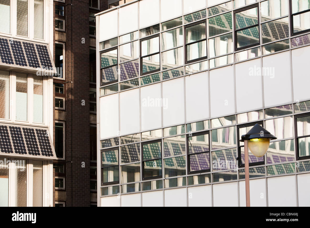 I pannelli solari si riflette in un edificio di vetro sul campus del Northumberland Università di Newcastle, a nord-est, UK. Foto Stock
