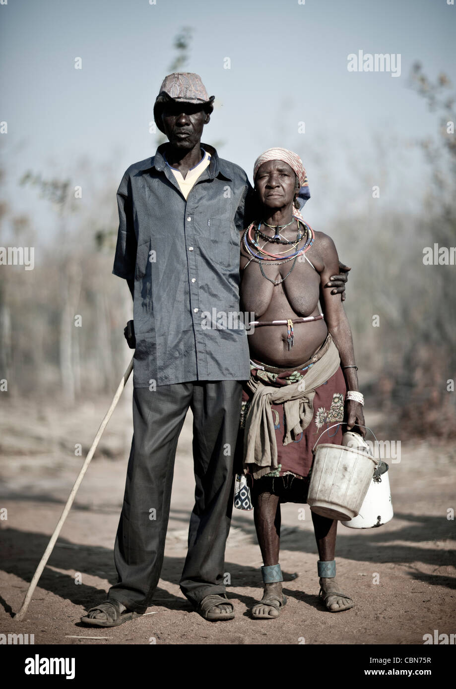 Vecchio Mudimba giovane con la donna vestita in modo tradizionale e l'uomo in Western Way, villaggio di Combelo, Angola Foto Stock