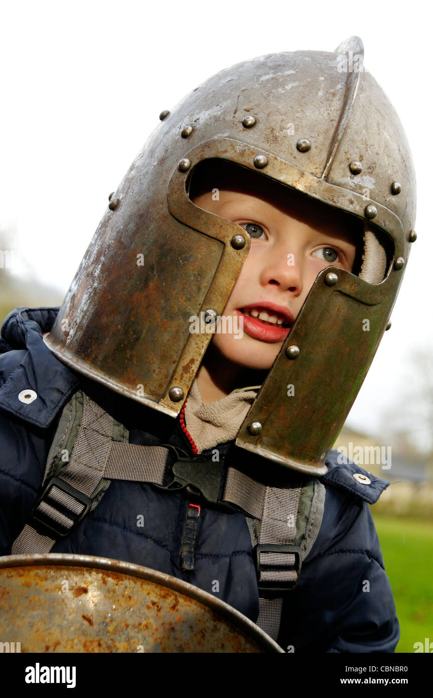 Un giovane ragazzo che indossa un casco dei cavalieri Foto Stock