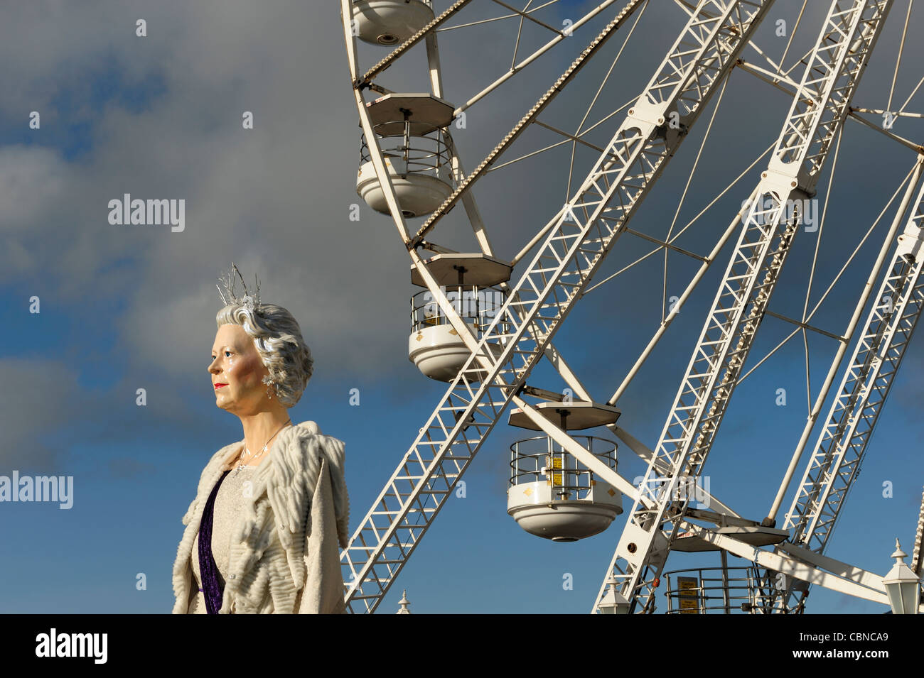 Una gigantesca statua della regina Elisabetta nella parte anteriore di una ruota panoramica Ferris in Chester Foto Stock
