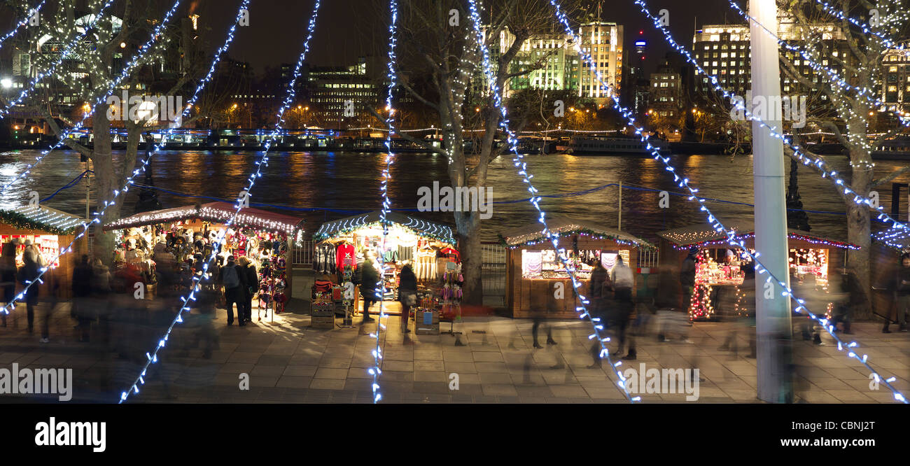 Vista il tradizionale Mercatino di Natale lungo la sponda sud della regina di Londra a piedi di notte Foto Stock