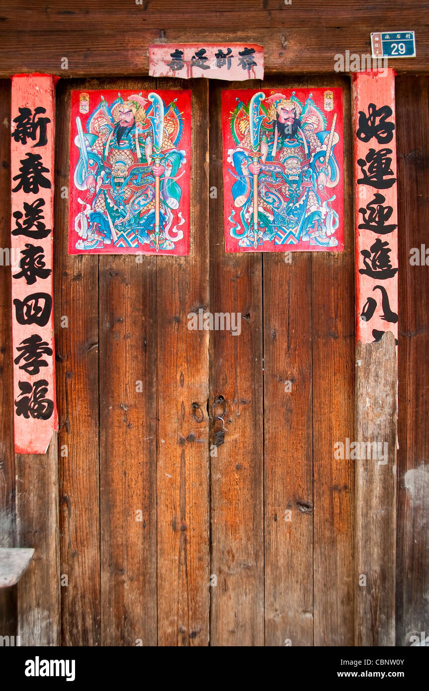 Anno Nuovo Cinese stampe e scorrere su una porta - villaggio nel distretto di Guangxi - Cina Foto Stock