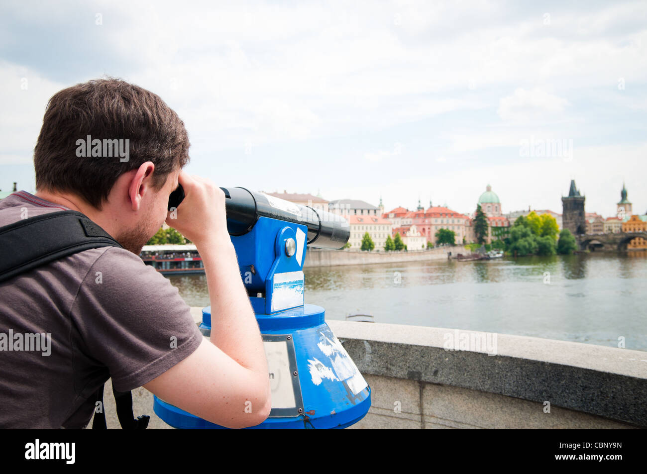 L'uomo guarda attraverso il telescopio a Praga Foto Stock
