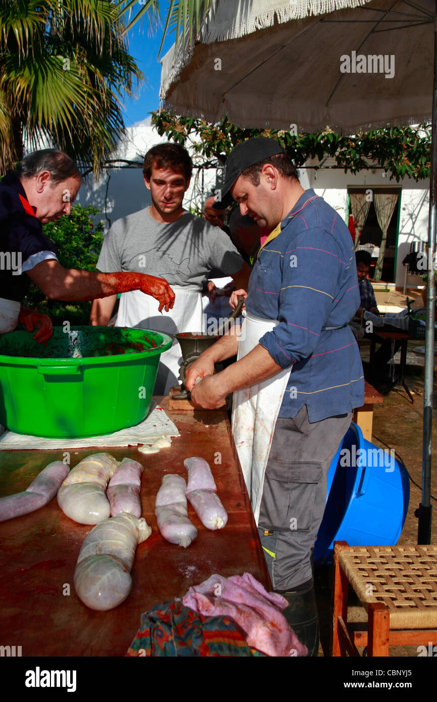 Compatrioti di riempimento intestini di maiale con la carne di suolo e spezie per fare le salsicce, Ibiza tradizionali di macellazione di suini Foto Stock