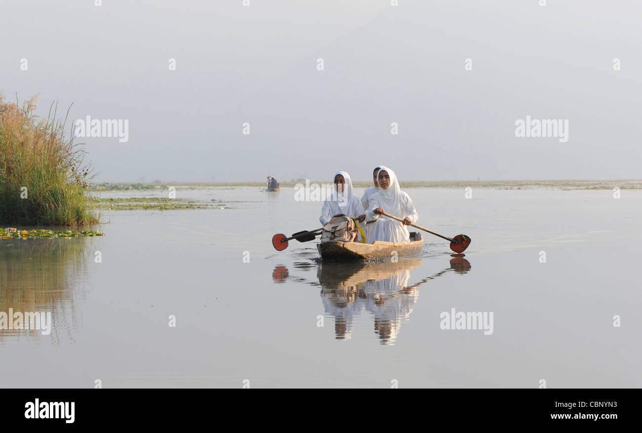 Le ragazze che indossano hijab bianco la pala a scuola in una canoa. Dal Lago. Srinagar Kashmir. India Foto Stock
