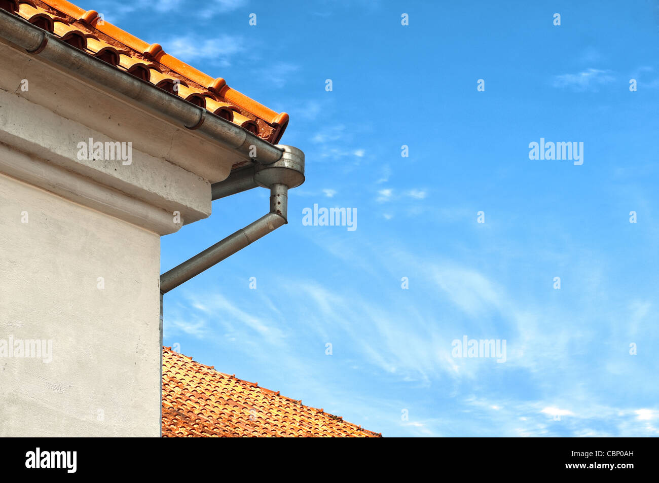 Splendidi vecchi tetti con tubo downtake e blu cielo nuvoloso in background Foto Stock