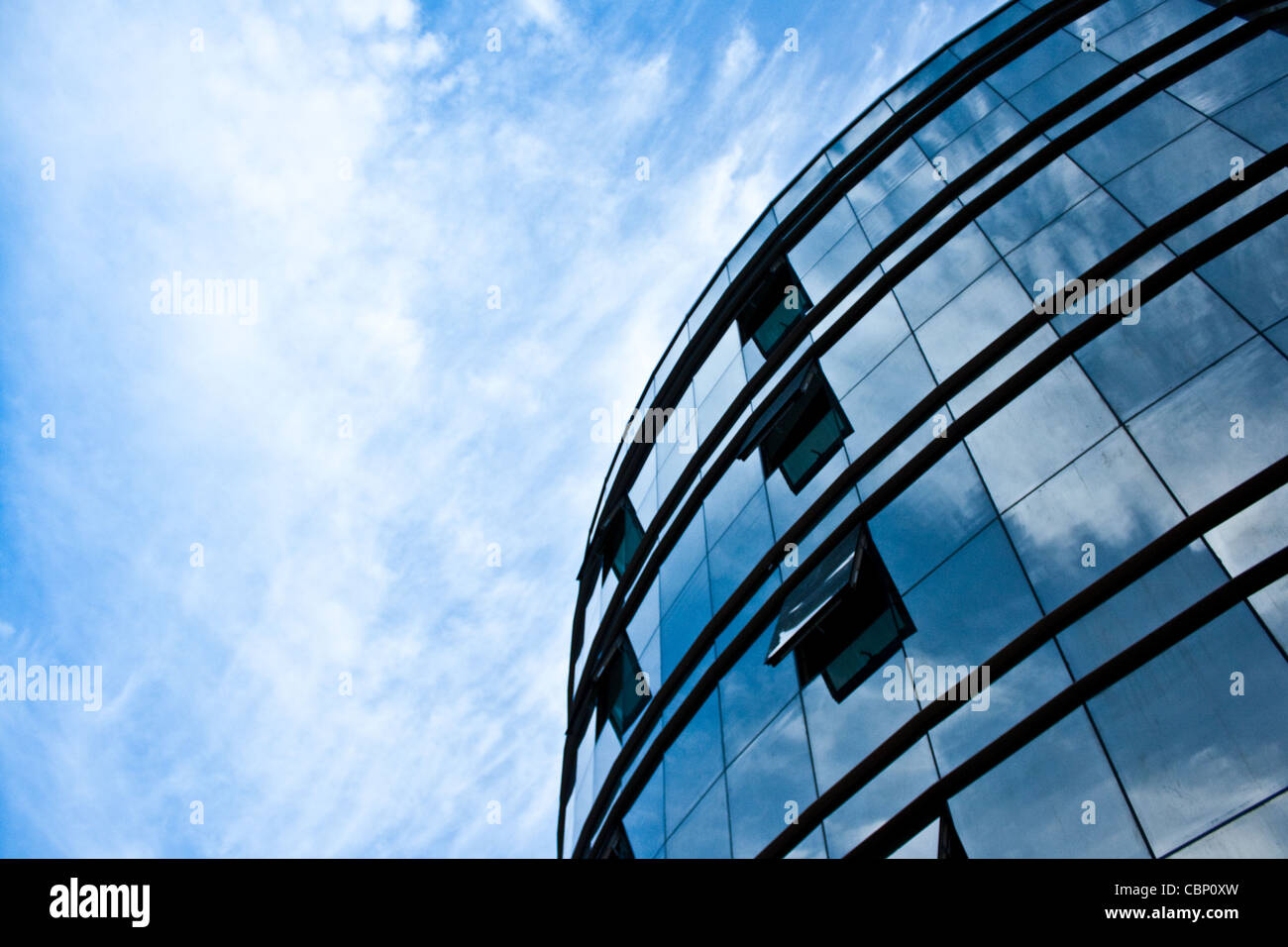 Moderno edificio con facciata in vetro con il riflesso del cielo e cielo nuvoloso0 Foto Stock