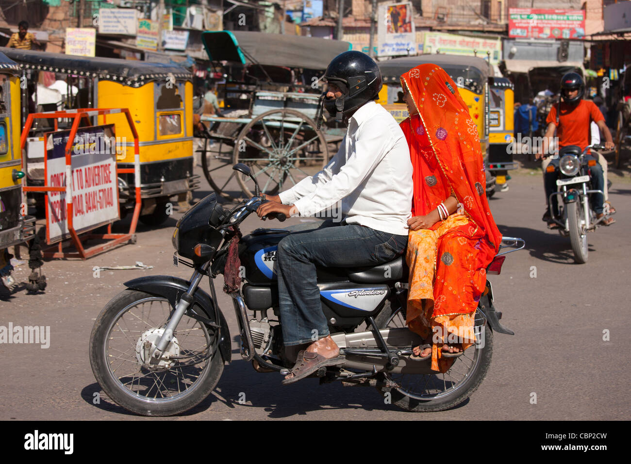 Indian giovane riding motociclo, scene di strada a Sardar Mercato a Girdikot, Jodhpur, Rajasthan, India settentrionale Foto Stock