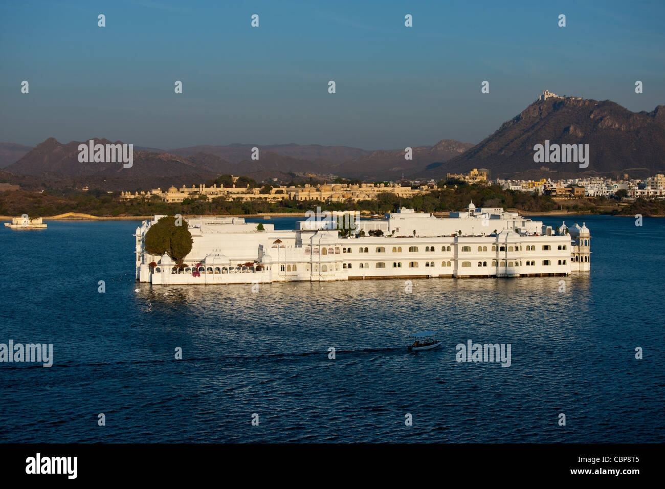 Lake Palace Hotel, Jag Niwas, sul sito dell'isola sul lago Pichola in mattina presto con la barca lasciando, Udaipur, Rajasthan, India Foto Stock