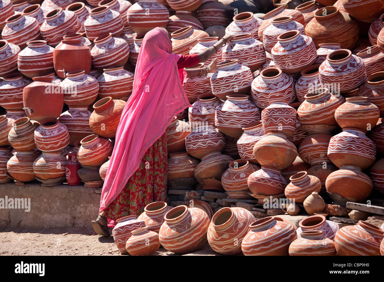 Donna indiana la vendita di argilla vasi d'acqua in vendita nella città vecchia Udaipur, Rajasthan, stato dell India occidentale, Foto Stock
