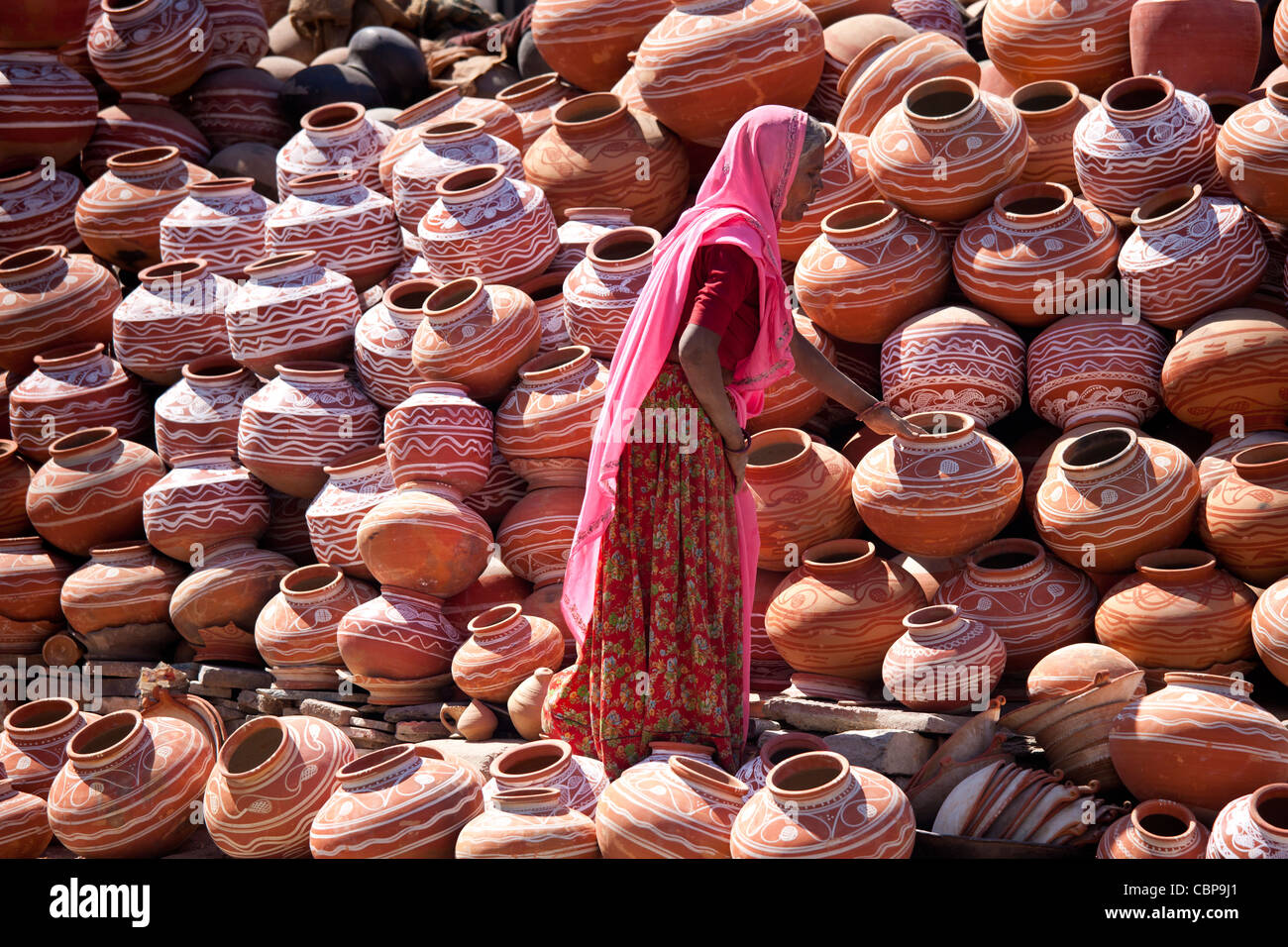 Donna indiana la vendita di argilla vasi d'acqua in vendita nella città vecchia Udaipur, Rajasthan, stato dell India occidentale, Foto Stock