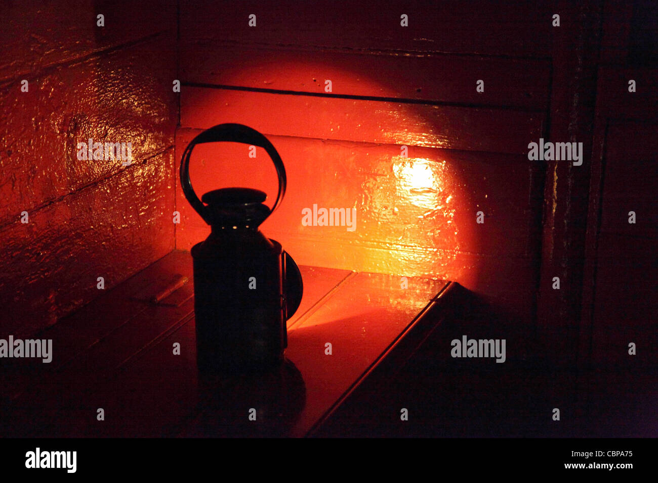 Vecchia ferrovia olio lampada colata di un bagliore rosso all'interno di un carrello, Tanfield Railway, North East England, Regno Unito Foto Stock