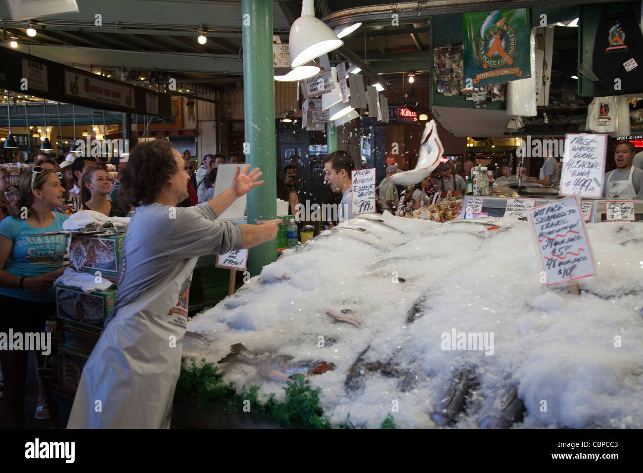 Gettando il salmone fresco presso il Pike Place Market pubblica, Seattle, Washington, Stati Uniti d'America Foto Stock