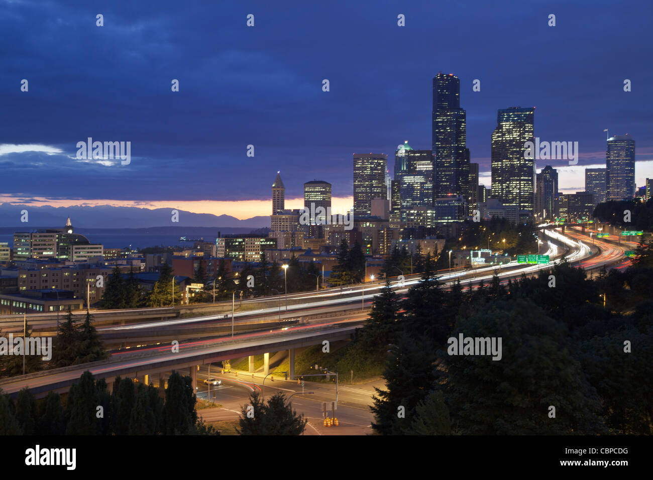 Luci della città al tramonto con il Puget Sound e montagne olimpiche, Seattle Washington, Stati Uniti d'America Foto Stock