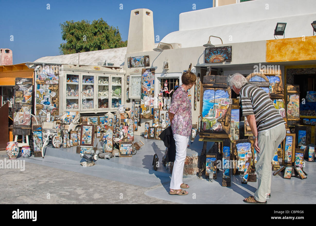 Turista giovane che guarda al negozio di souvenir in negozio in Fira di Santorini in Grecia nelle isole greche Foto Stock
