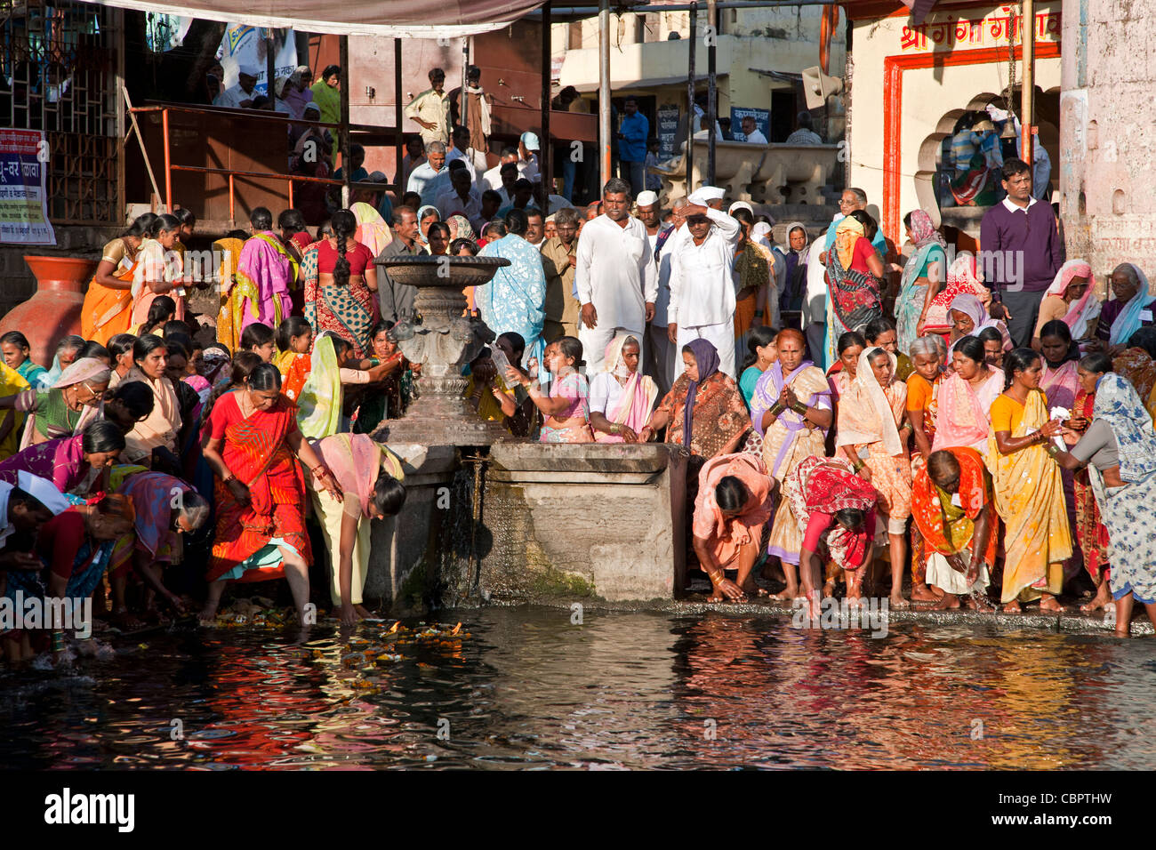 Le donne che prendono il bagno rituale nelle sacre acque del fiume Godavari. Ram Kund. Nasik. India Foto Stock