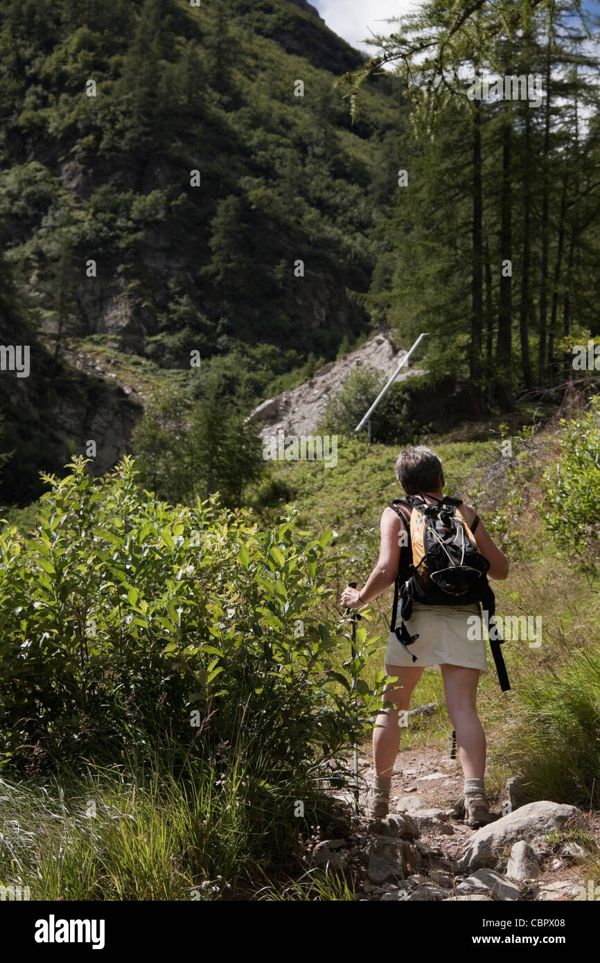 Donna passeggiate in collina sopra Pecetto vicino a Macugnaga, nelle Alpi italiane. Foto Stock