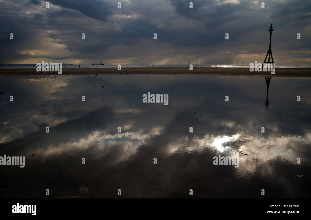 Il fiume Mersey scorre sotto cieli moody passato Crosby beach Foto Stock