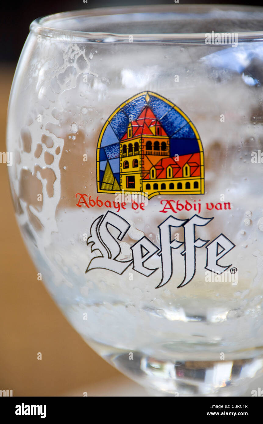 Verticale fino in prossimità di un vuoto di Leffe birra in vetro. Foto Stock