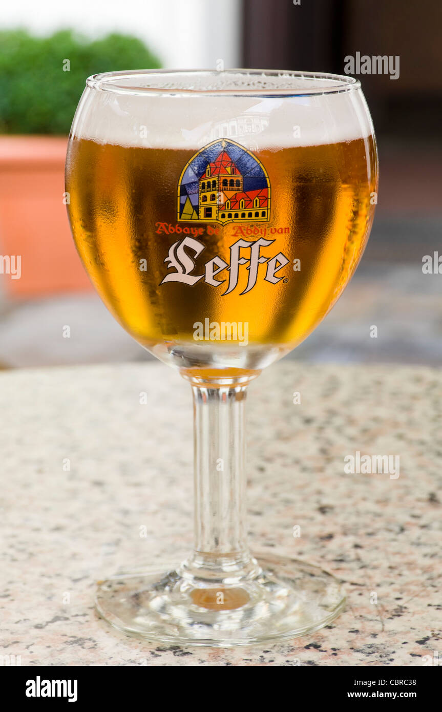 Verticale fino in prossimità di un Leffe Bionda birra in un tradizionale calice di vetro sagomato. Foto Stock