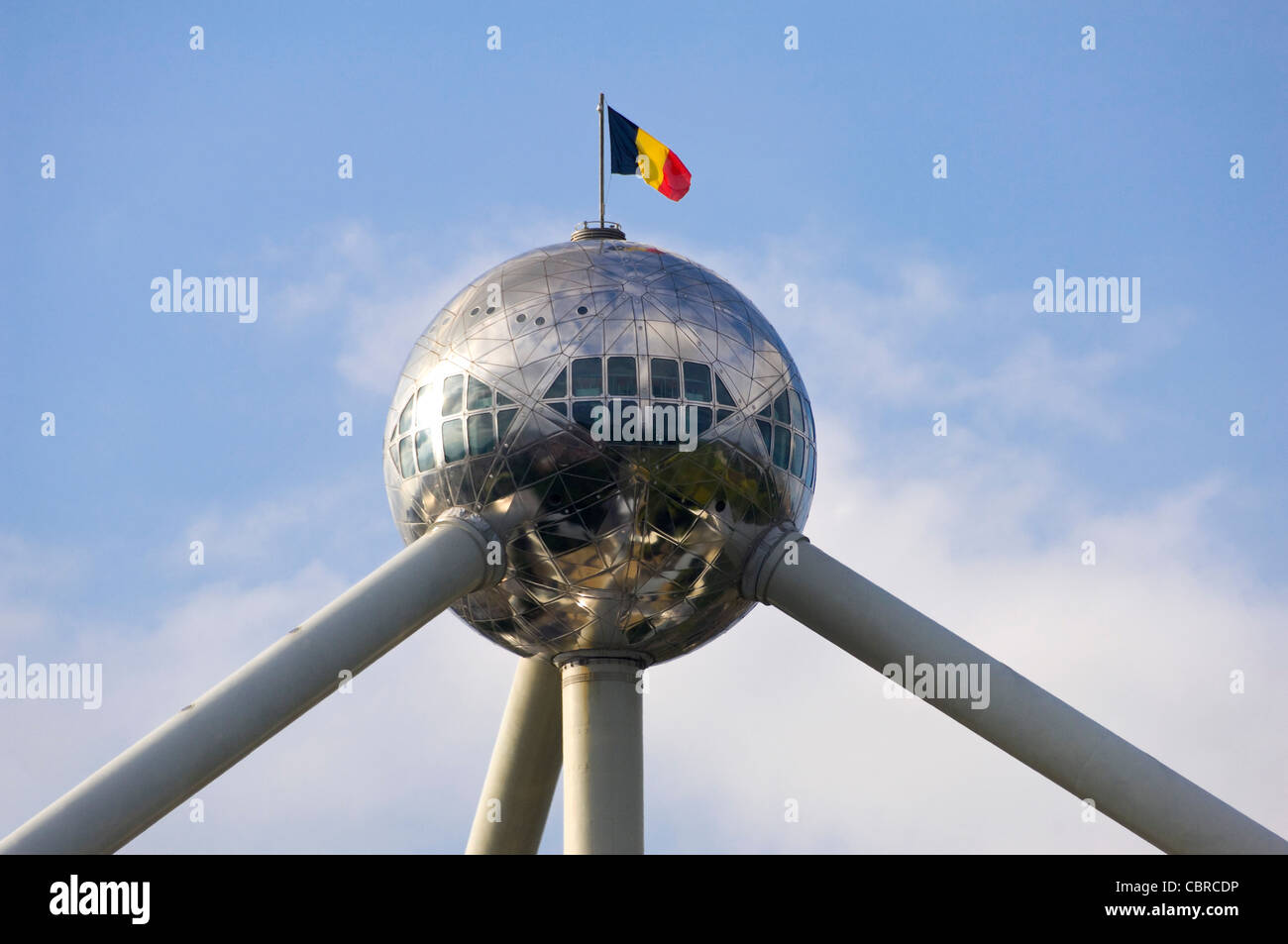 Orizzontale fino in prossimità della sommità superiore Ambito di Atomium in Heysel Park con la bandiera belga contro un cielo blu. Foto Stock