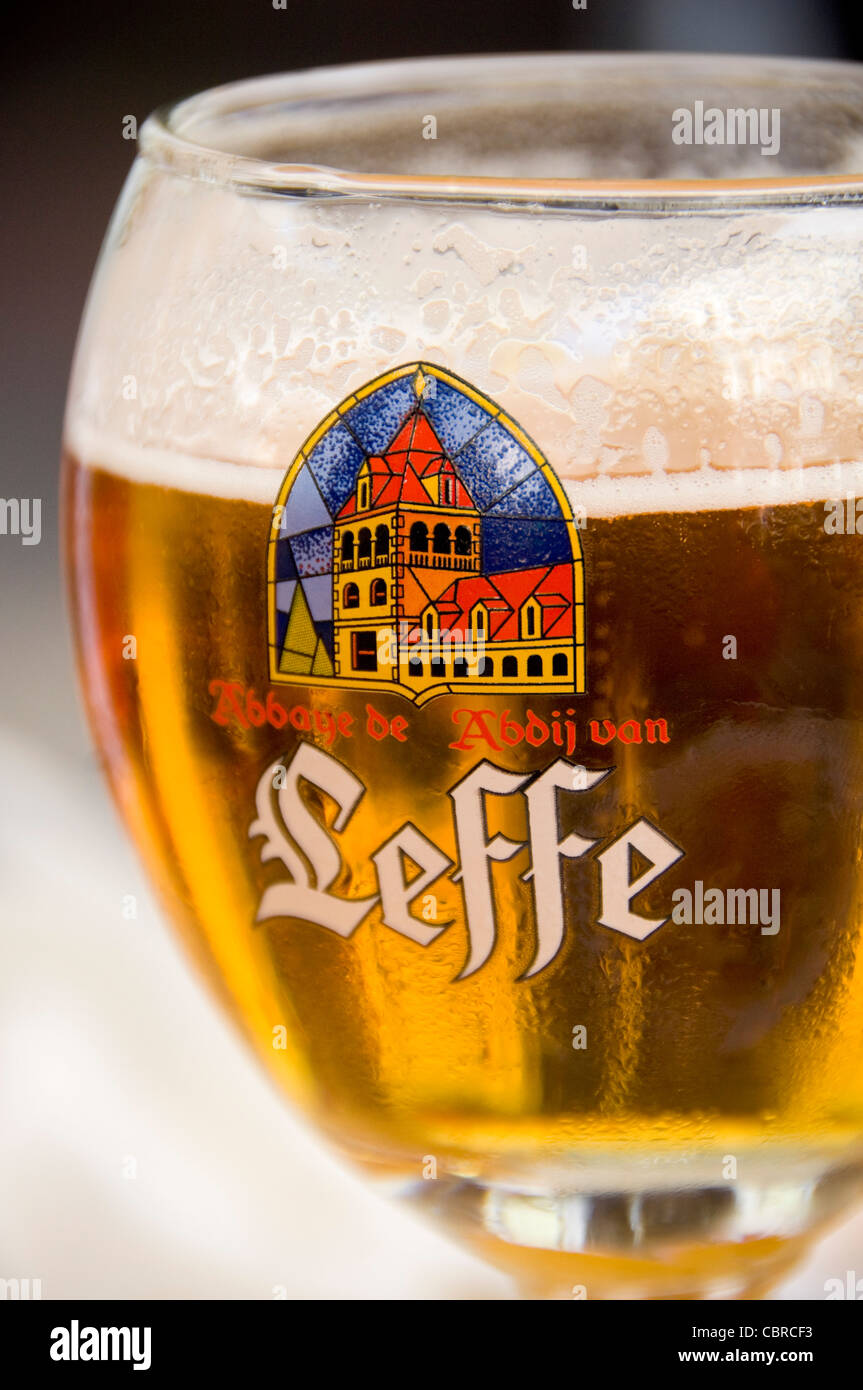 Verticale fino in prossimità di un Leffe Bionda birra in un tradizionale calice di vetro sagomato. Foto Stock