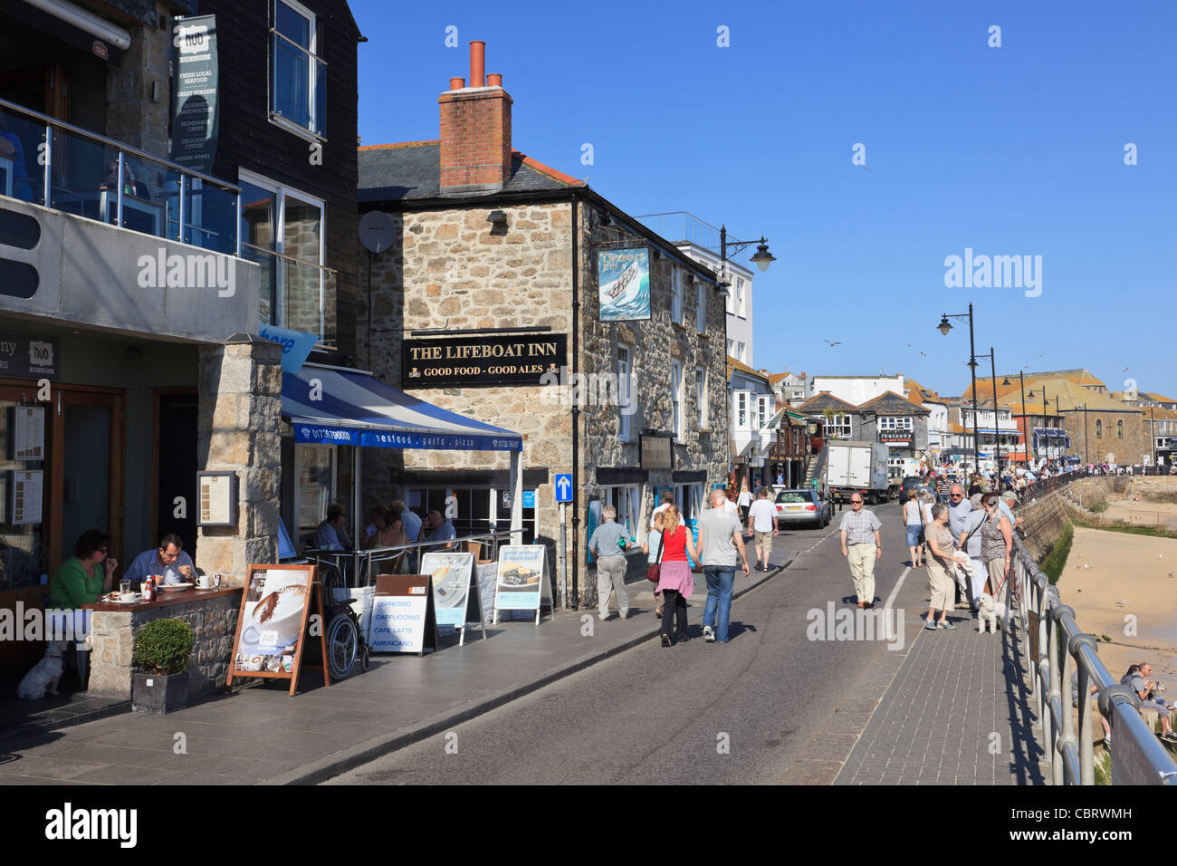 La passeggiata sul lungomare con i turisti nella famosa località balneare. Wharf Road, St Ives, Cornwall, Inghilterra, Regno Unito, Gran Bretagna. Foto Stock