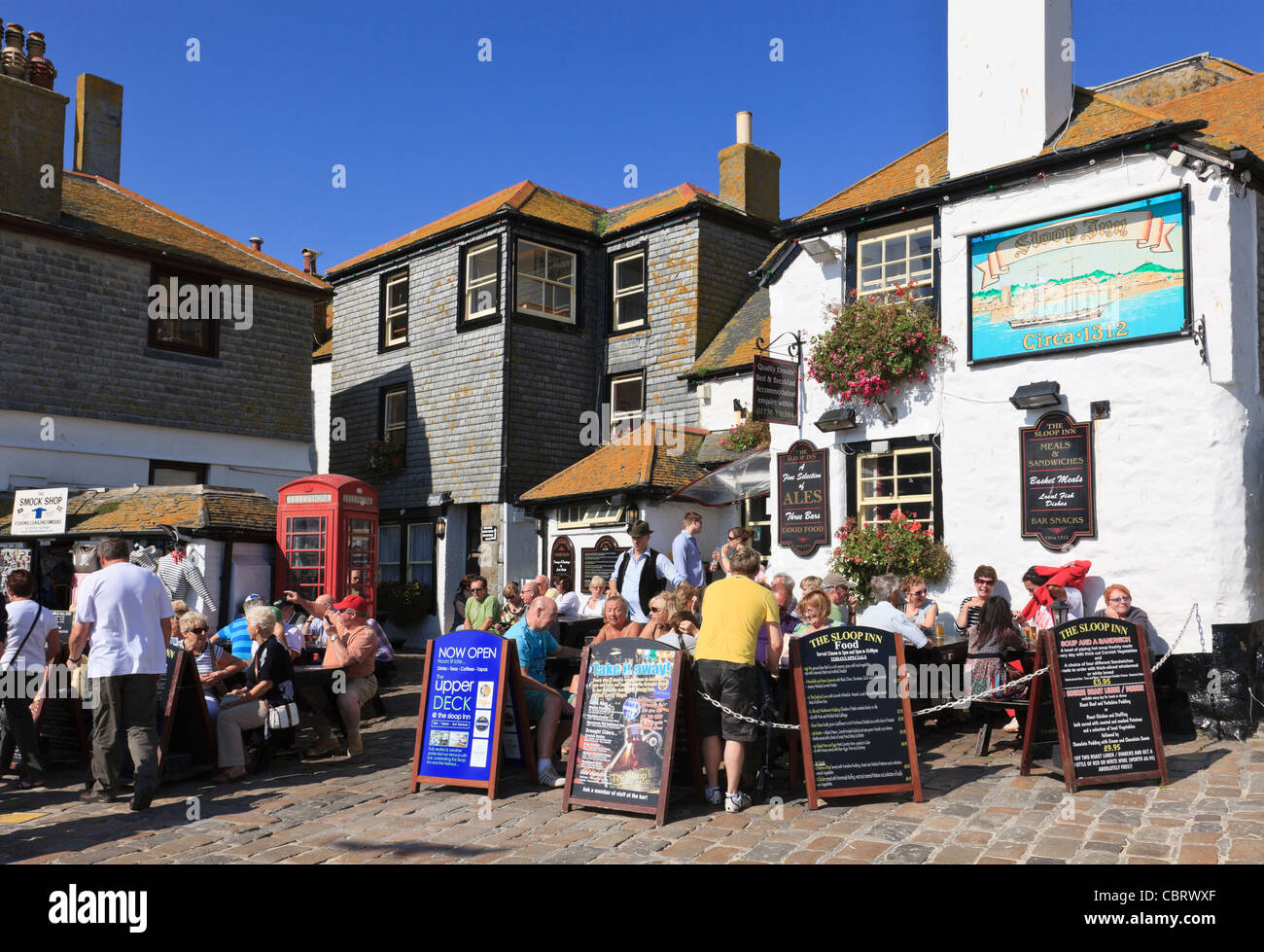 Lo Sloop Inn tradizionale pub del 14 ° secolo occupato con clienti turisti seduti all'aperto nella birreria all'aperto. St Ives, Cornovaglia, Inghilterra, Regno Unito, Gran Bretagna Foto Stock