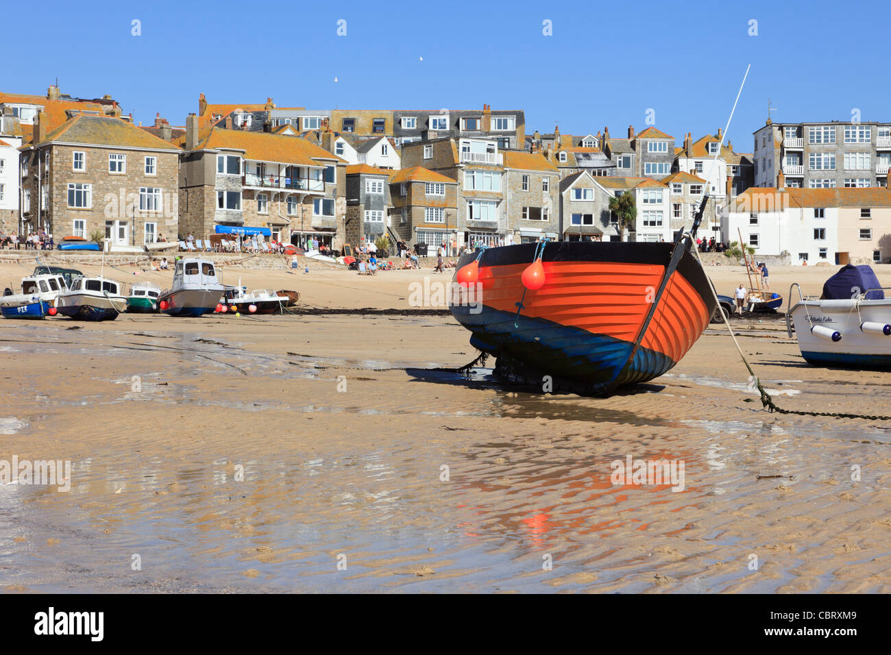 Rosso barca ormeggiata nel porto di sabbia con la bassa marea in west country città costiera. St Ives, Cornwall, Inghilterra, Regno Unito, Gran Bretagna. Foto Stock
