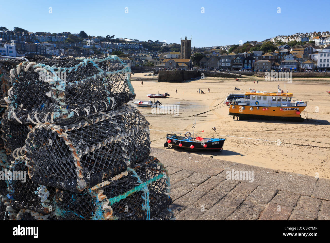 Lobster cantre sulla parete del porto con barche ormeggiate a bassa marea nel piccolo porto di pesca. St Ives, Cornwall, Regno Unito Foto Stock
