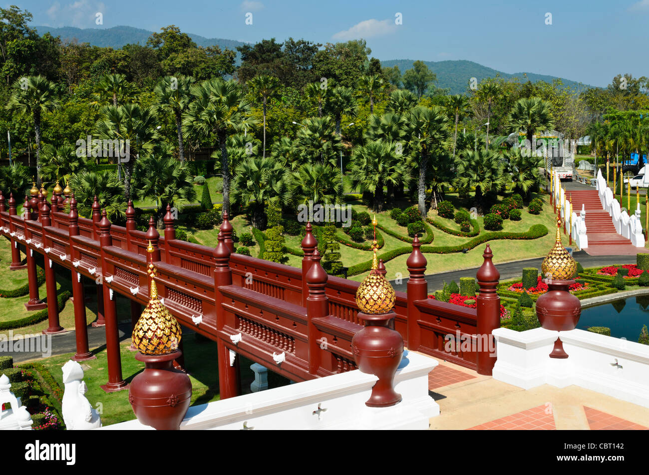 La vista dal balcone del Royal Pavilion al Royal Flora Ratchaphruek in Chiang Mai Thailandia di legno ponte pedonale e palme Foto Stock