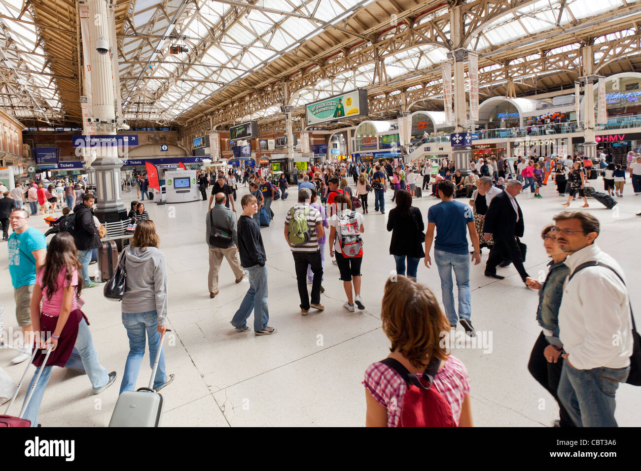 I passeggeri in viaggio, commuter camminando in Victoria Rail stazione ferroviaria di Londra, Inghilterra. Foto Stock