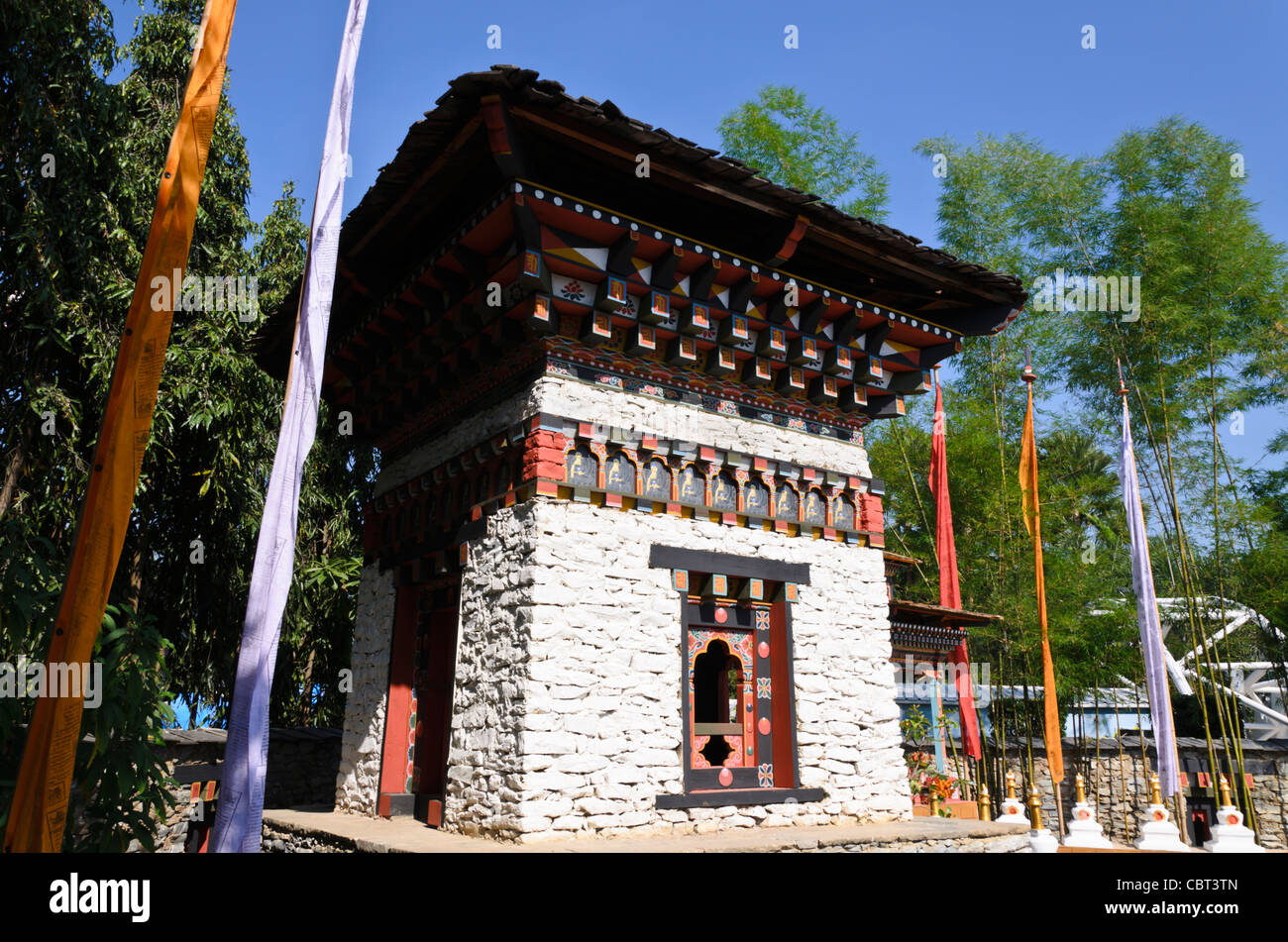 Tradizionale stile himalayano pietra e legno edificio che ospita grandi Buddista Tibetana ruota di preghiera a expo in Chiang Mai Thailandia Foto Stock