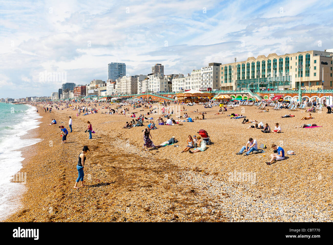 Sun bagnanti e nuotatori rilassante sulla spiaggia dell'oceano a Brighton, Inghilterra. Foto Stock