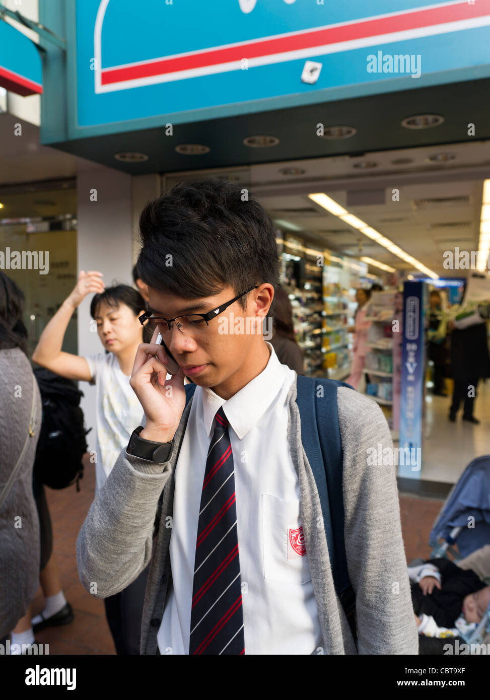 Dh Cina telefoni cellulari adolescente HONG KONG Schoolboy adolescente utilizzando un mobile telefono cellnet chinese boy telefono asia Foto Stock