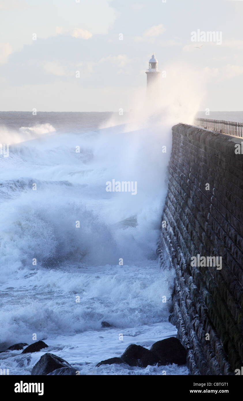 Onde che si infrangono sulla parete nord del molo di Tynemouth, North East England, Regno Unito Foto Stock