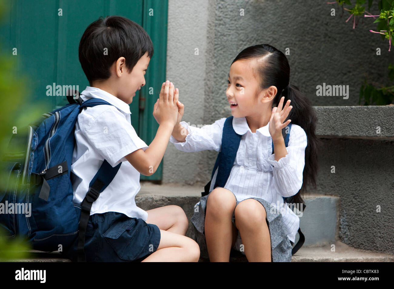 Scuola di due bambini che giocano al di fuori Foto Stock