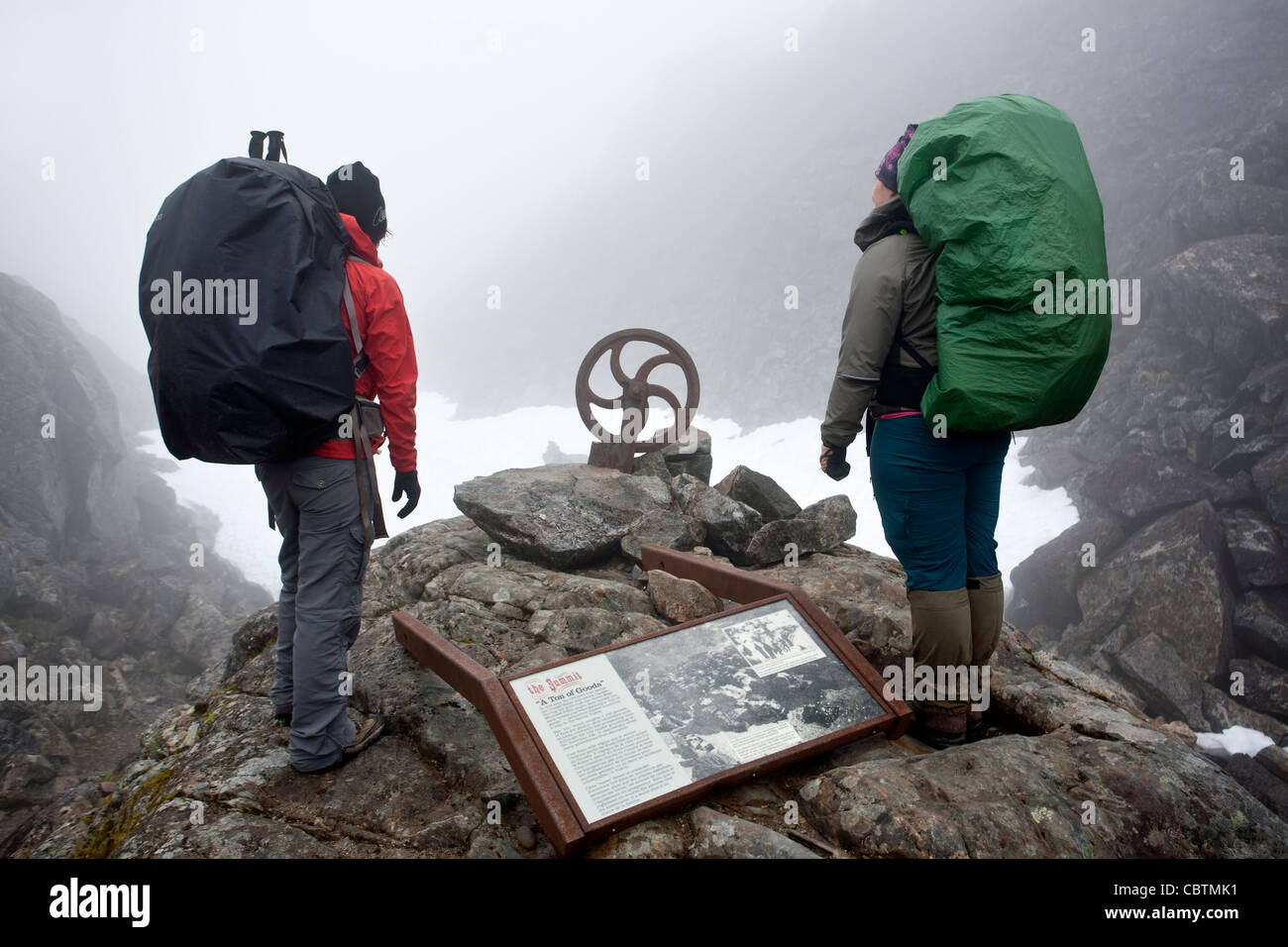 Il trekking di lettura di un segno interpretative. Chilkoot Pass summit. Chilkoot Trail. USA-Canada border Foto Stock