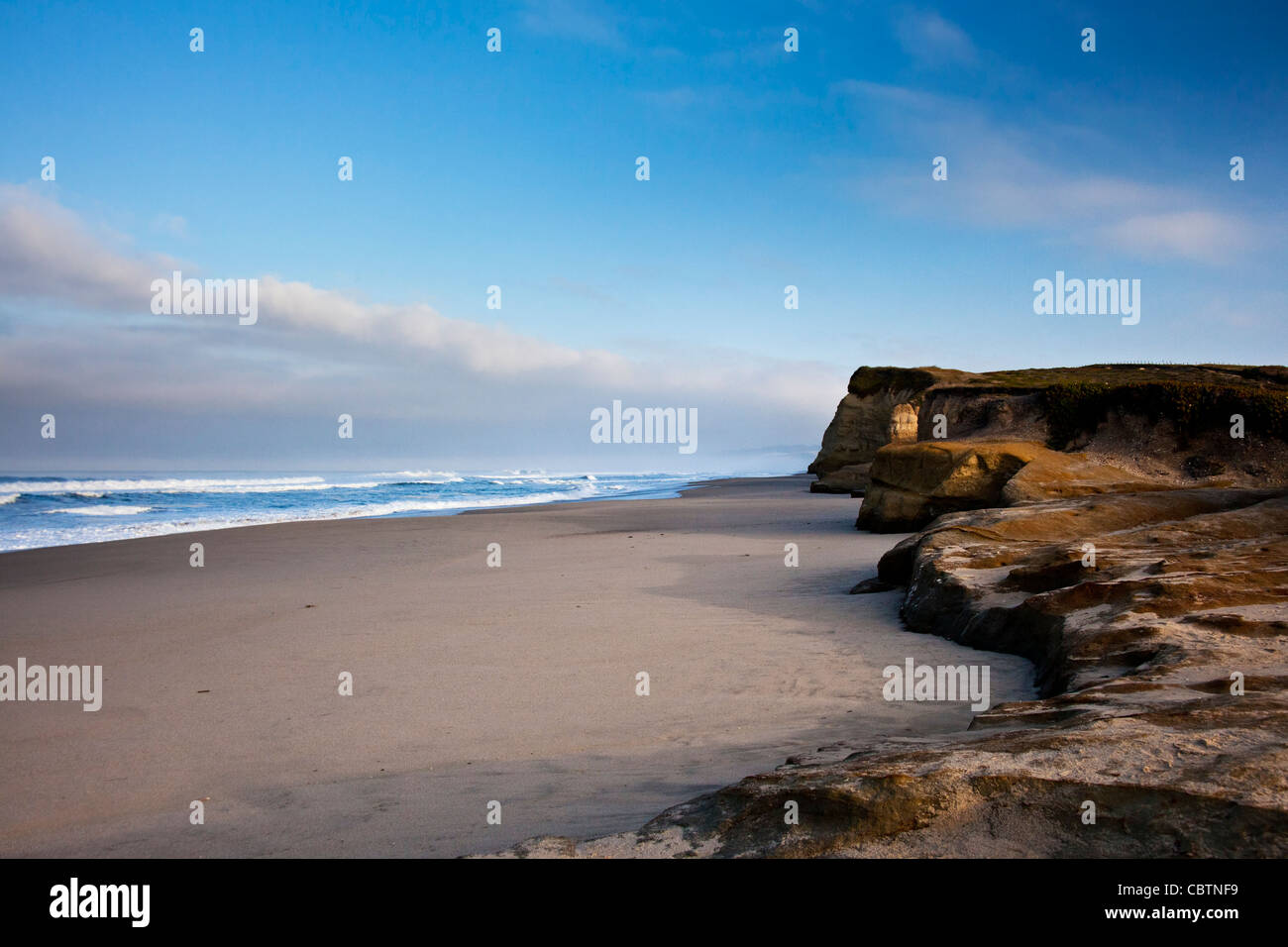Sky, nuvole oceano e Riva di disegnare linee per i lontani bluff a uno stato spiaggia sulla costa della California a sud di San Francisco. Foto Stock