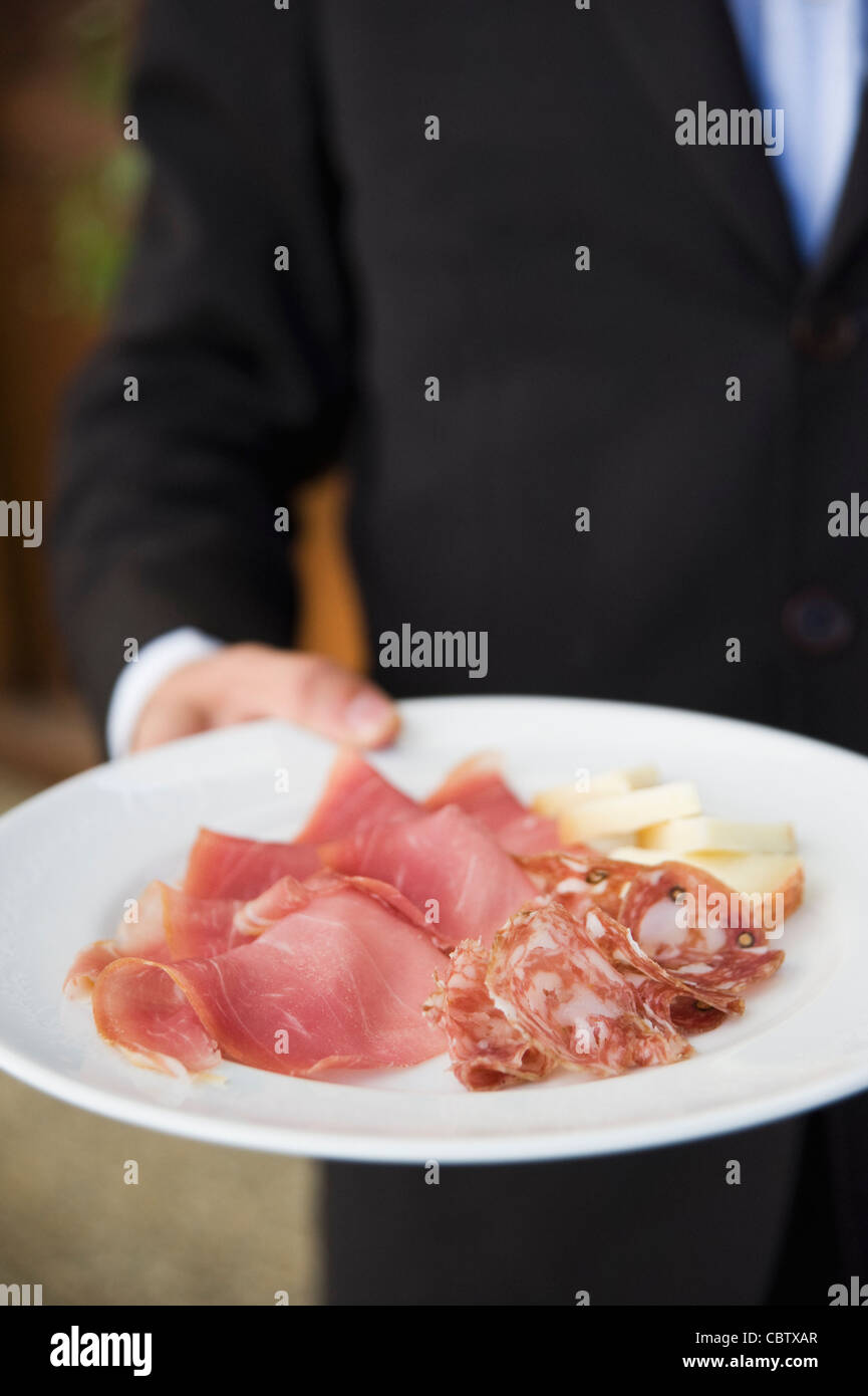 Cameriere piastra portante del vulcanizzato salumi italiani Foto Stock