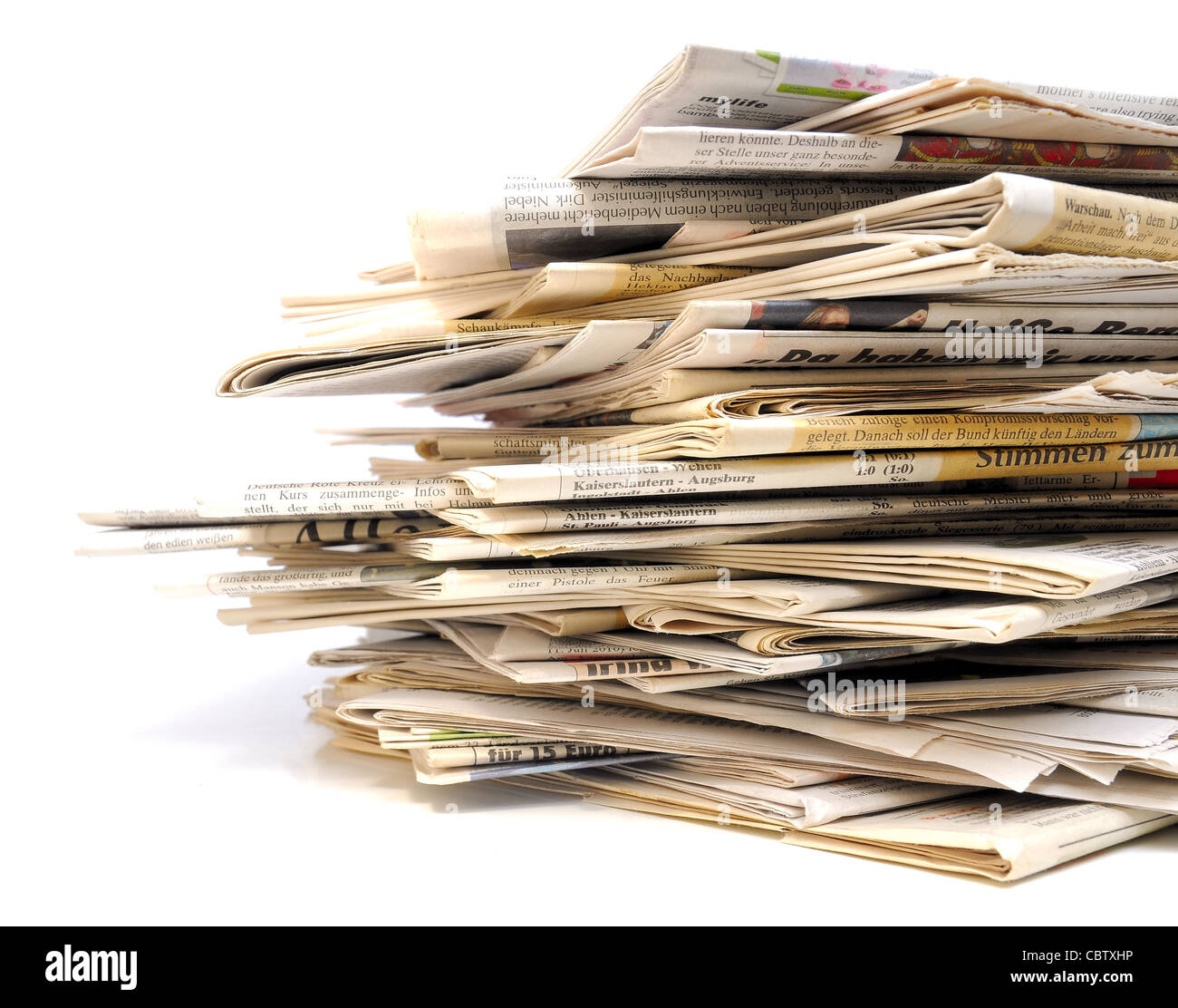 Pila di vari quotidiani su sfondo bianco Foto Stock