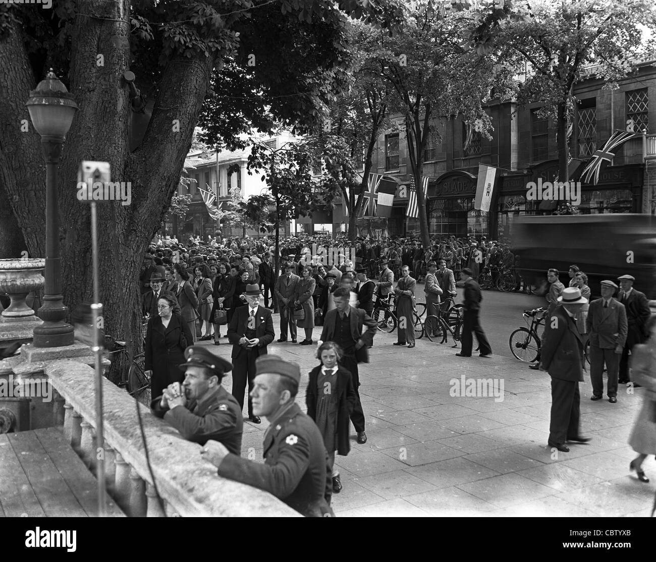 I membri dell'American Service le forze e i cittadini britannici il riempimento street in Inghilterra durante la seconda guerra mondiale Foto Stock