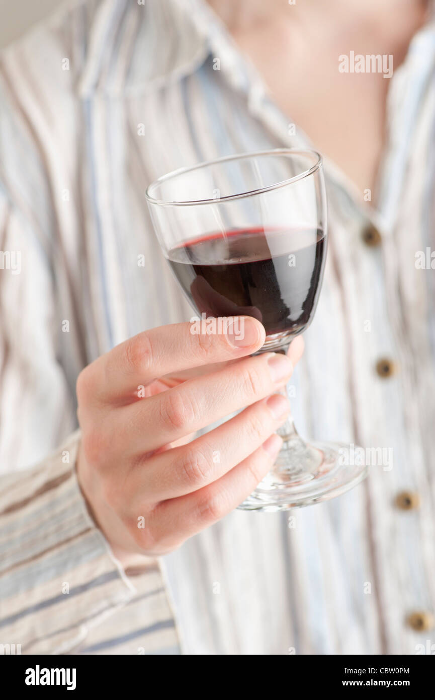 Donna con in mano un bicchiere di vino rosso Foto Stock