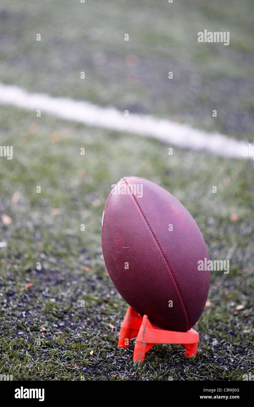 Il football americano e il raccordo a T sul campo di calcio Foto Stock