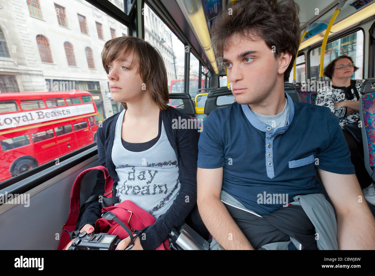 Tre passeggeri a cavallo su un autobus a due piani nel centro di Londra Foto Stock