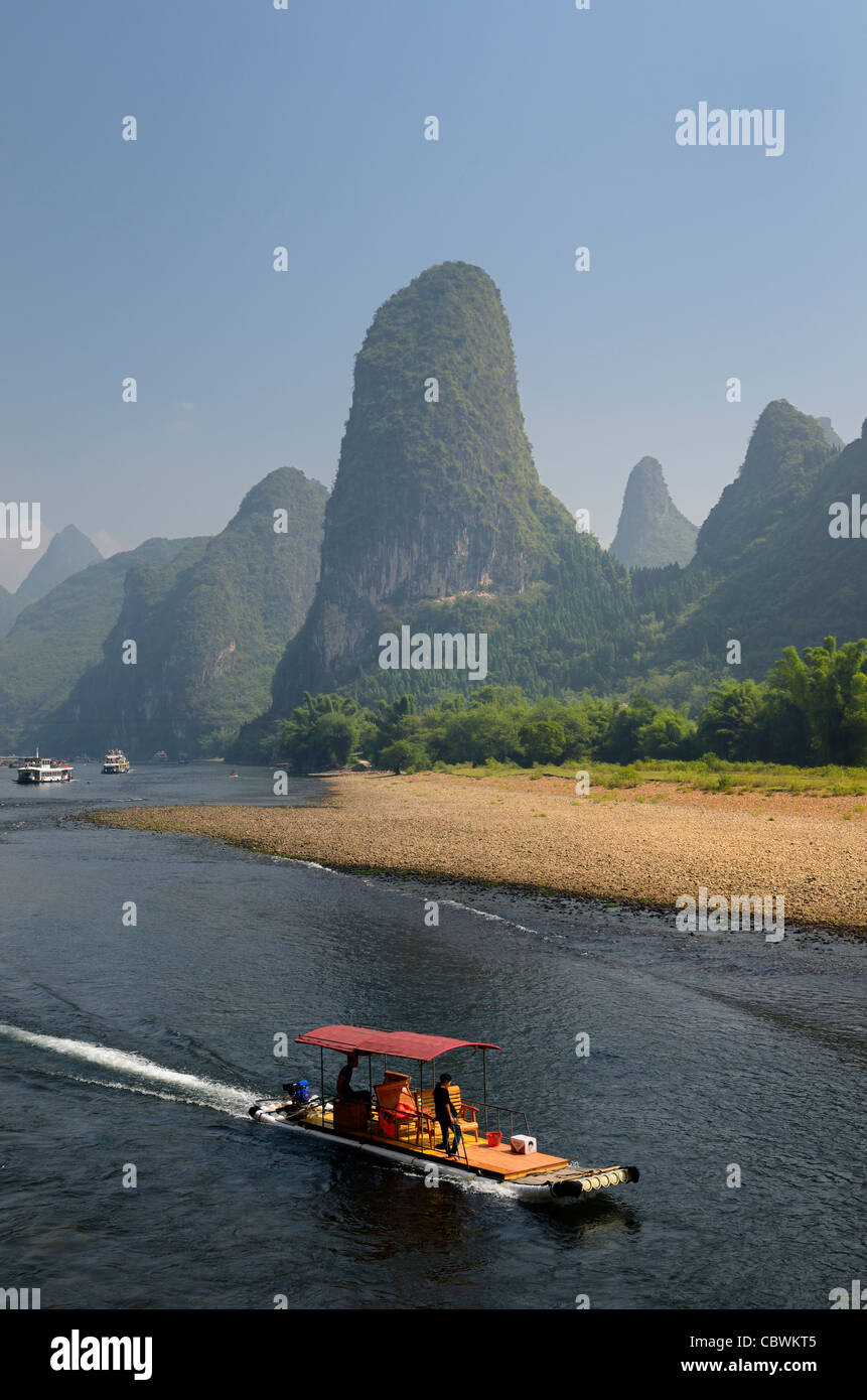 Tour in barca raft che si muove in basso lungo il fiume Li Guangxi Cina con alto Carso coni di montagna Foto Stock
