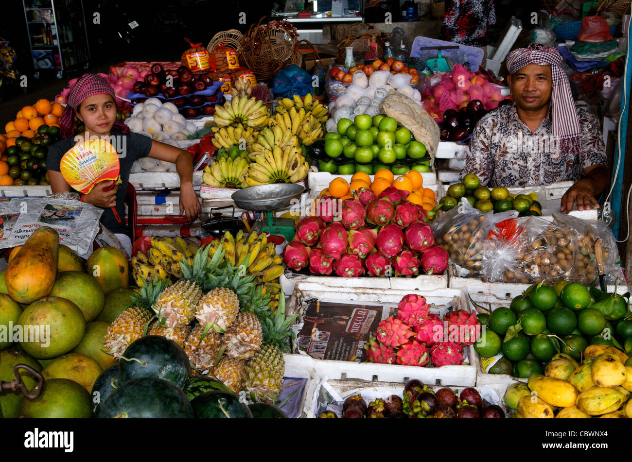 Venditori di frutta che indossa kramas (tradizionali sciarpe cambogiano) & display frutta w/ banane, Drago & frutta mele, Siem Reap, Cambogia. crdit: Kraig Lieb Foto Stock