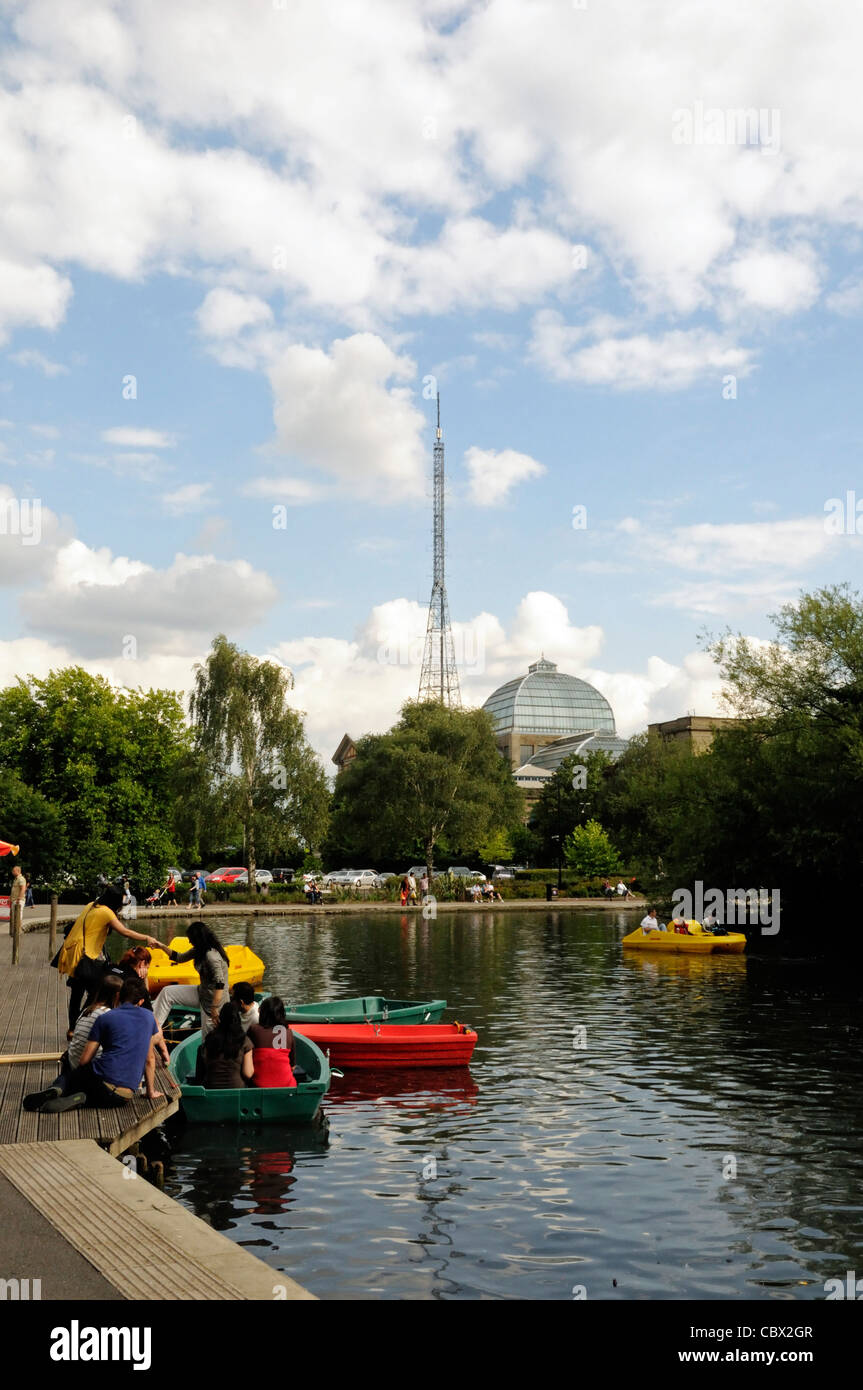 Gite in barca sul lago del Parco di Alexandra Palace e il montante della trasmissione in background Londra Inghilterra REGNO UNITO Foto Stock