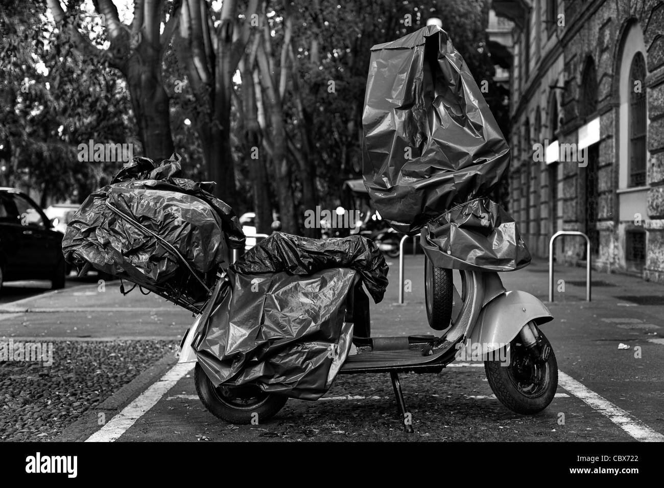 Scooter vespa avvolti in plastica per le strade di Milano, Italia Foto Stock